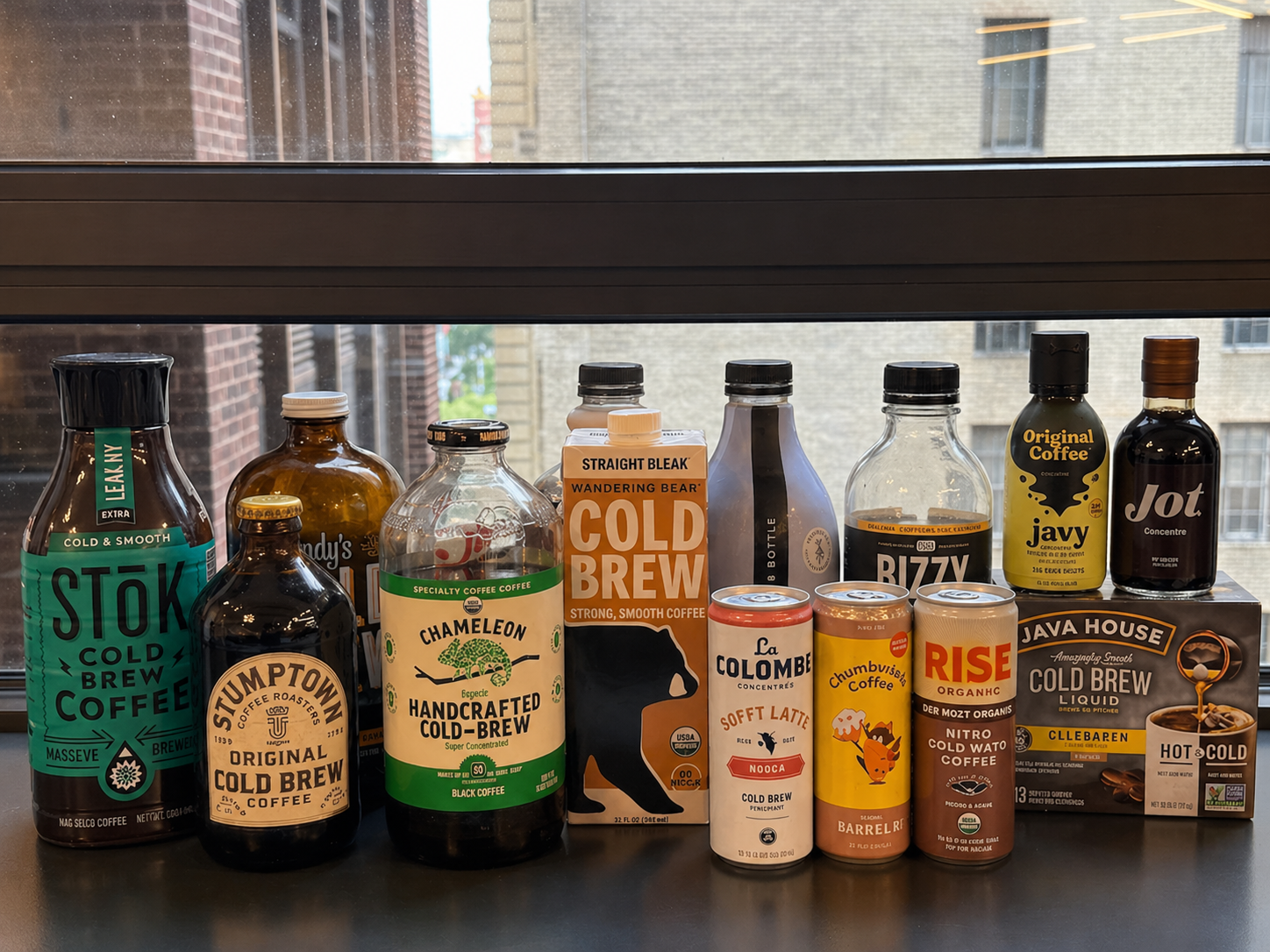Tester sipping cold brew next to Wandering Bear, La Colombe, and Javvy products